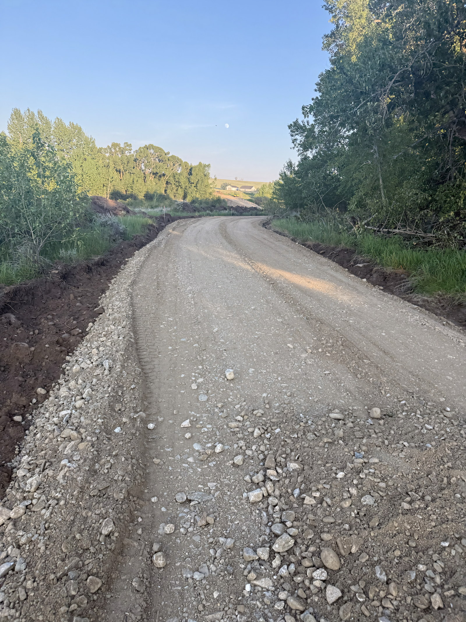 Fresh gravel road through green pasture at East Bench Overlook