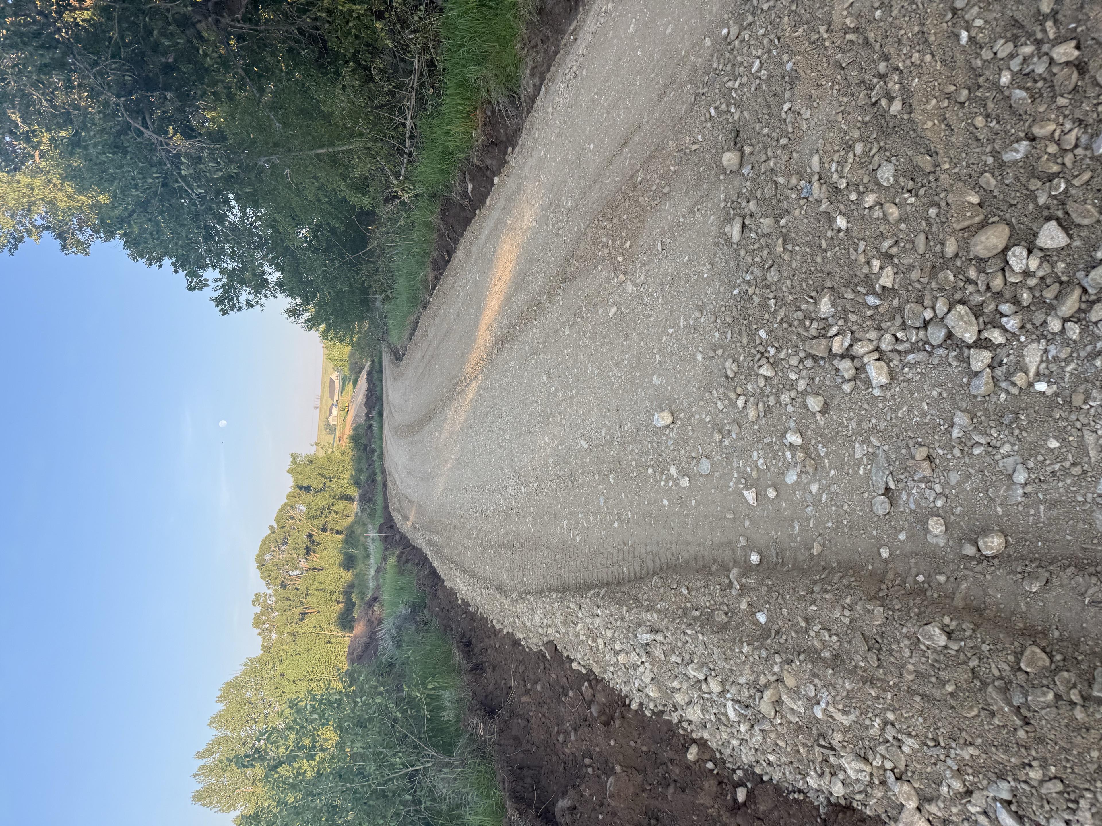 Fresh gravel road through green pasture at East Bench Overlook