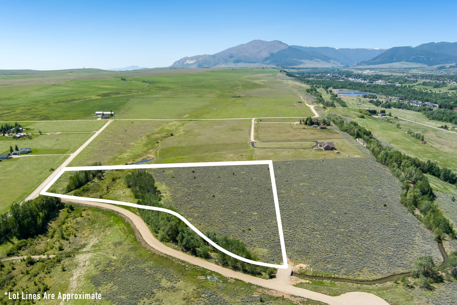 Pleasant Drive curving past Lot 2 with the green valley and mountain range beyond
