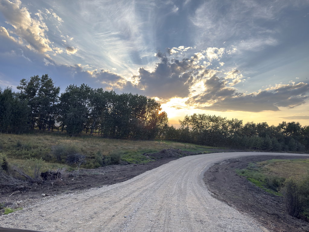 Gravel road curving through the east bench at sunset near Red Lodge, Montana